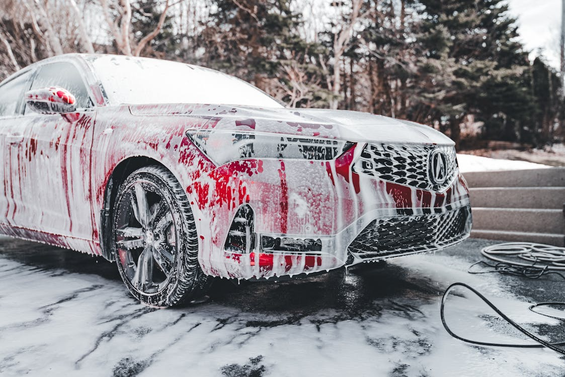 Luxury car being washed with foam and soap at Wallace Automotive.
