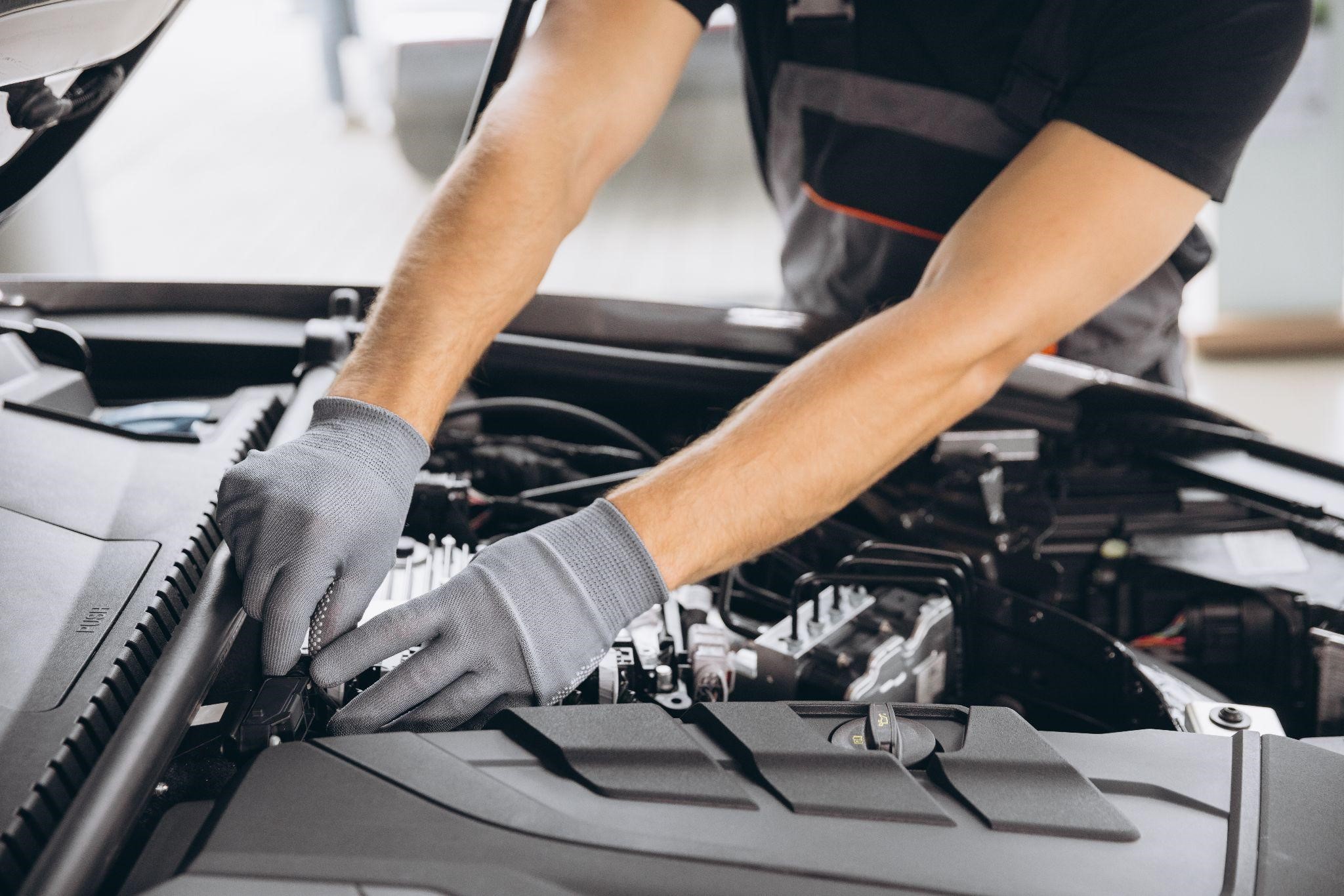 Skilled technician performing engine repair at Wallace Automotive, auto repair shop.