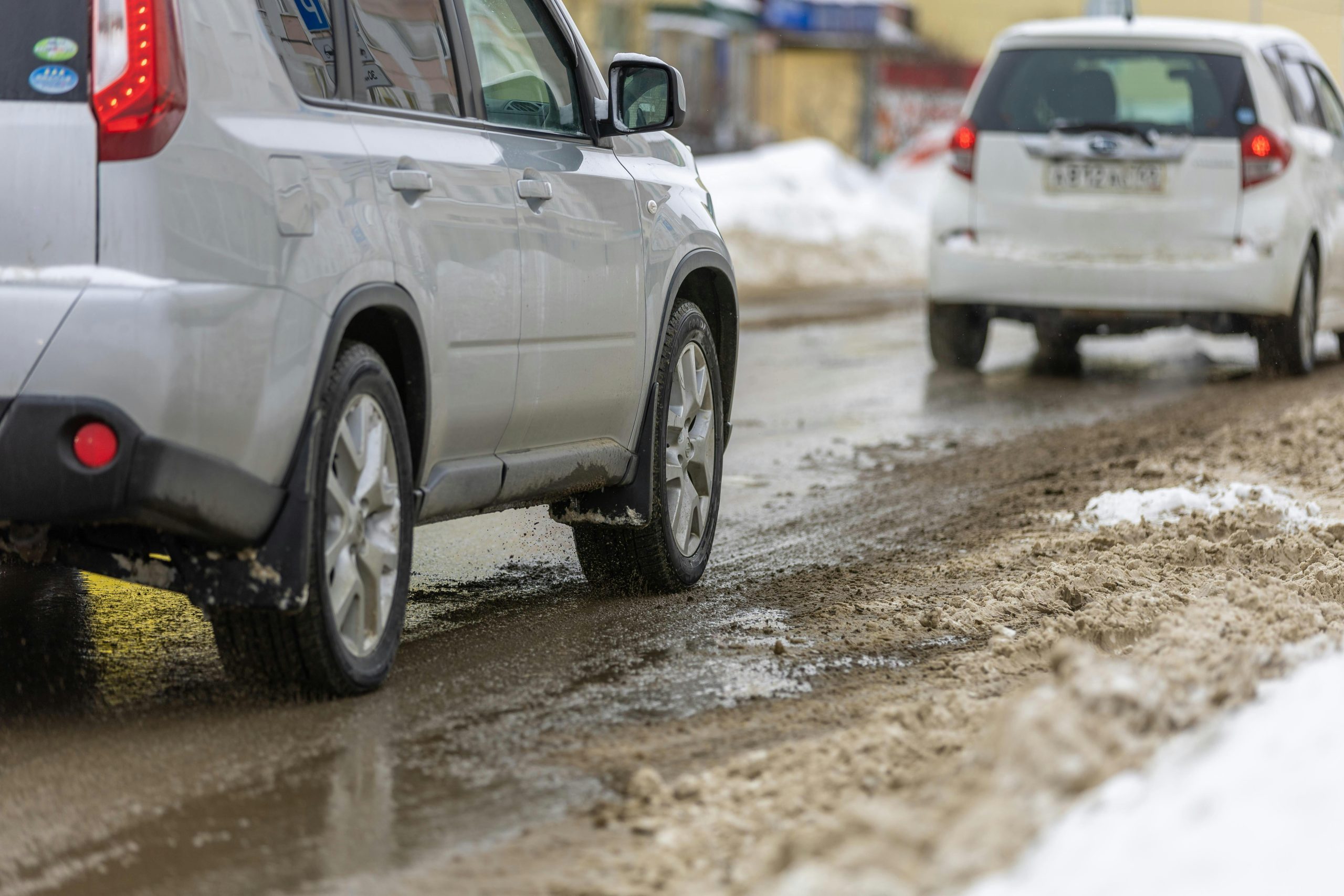 Winter driving, muddy roads, snow, vehicles, automotive service, road safety.