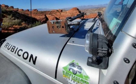 Jeep Rubicon with offroad accessories in desert terrain.