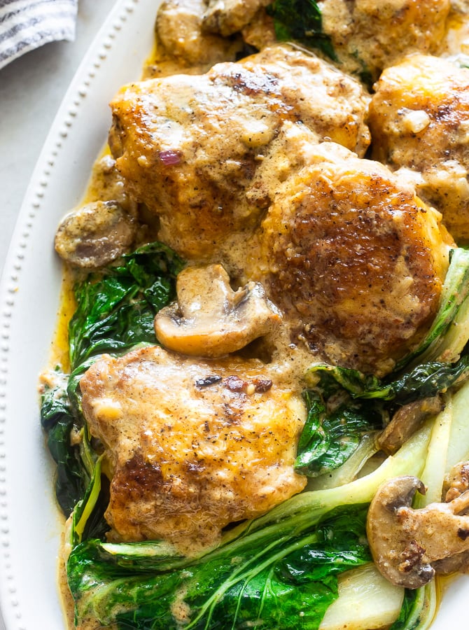 a serving dish with smothered chicken and bok choy 