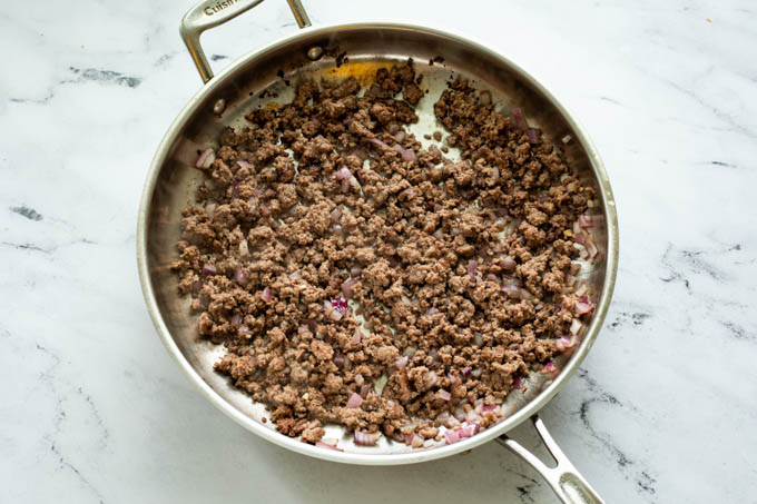 A skillet with ground beef for taco pasta 