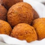 a bowl of golden brown round hush puppies