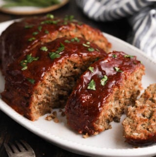 A photo of the Best Meatloaf Recipe with a peppery ketchup and brown sugar glaze on a serving platter