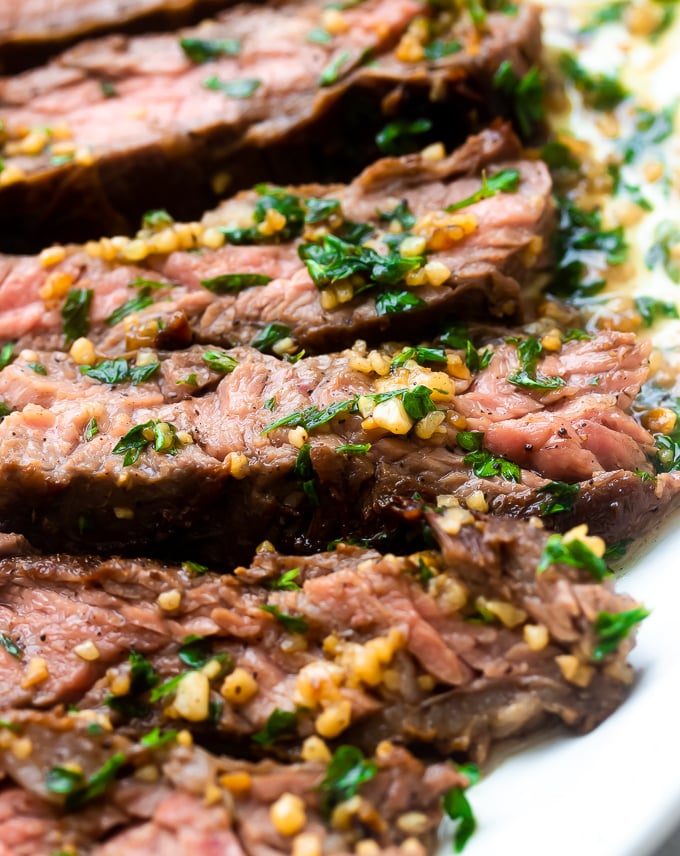 A plate of juicy tender Brazilian Steak with garlic butter drizzled on top