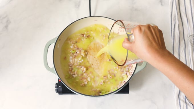 Broth in a pot with sauteed vegetables