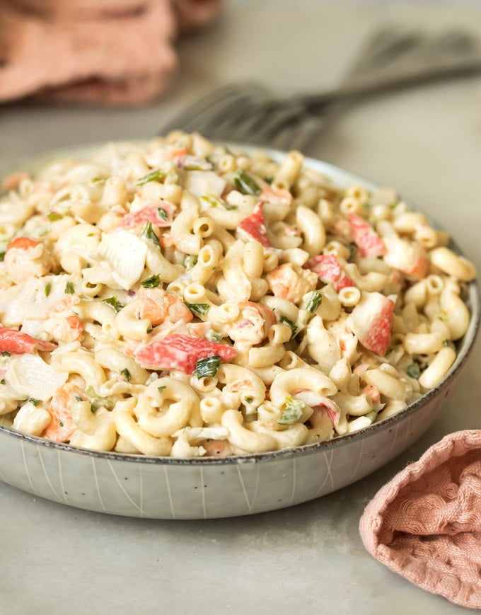 A bowl of the best creamy seafood macaroni salad with fresh parsley, shrimp, crab, and elbow macaroni