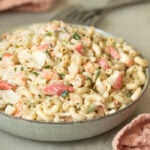 A bowl of the best creamy seafood macaroni salad with fresh parsley, shrimp, crab, and elbow macaroni
