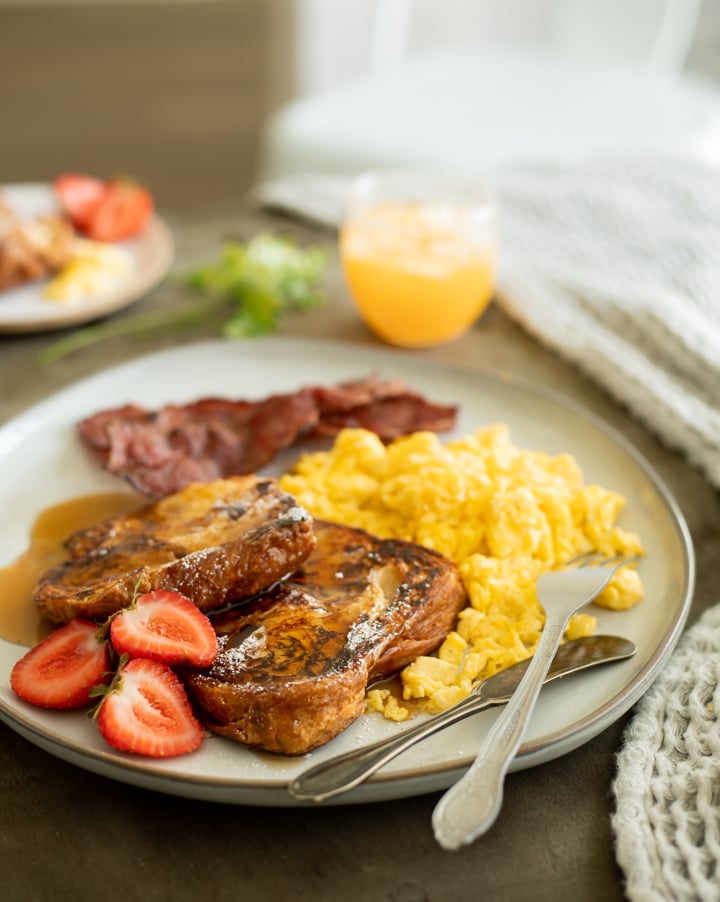 a plate of stacked french toast with butter