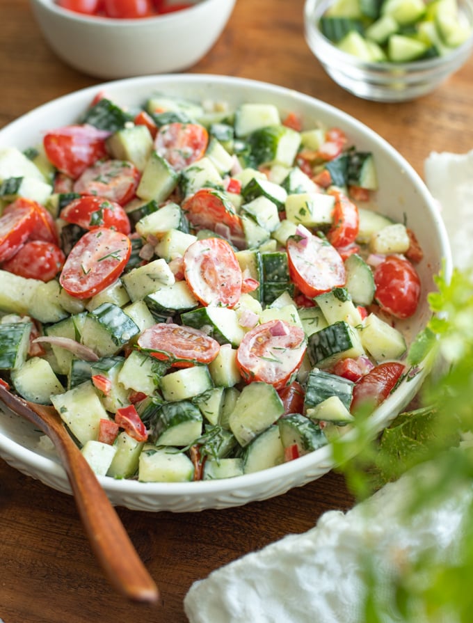 Tomato cucumber salad in a bowl with creamy dill dressing