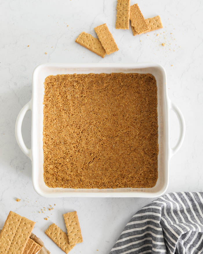 A picture of graham cracker crust in a baking pan