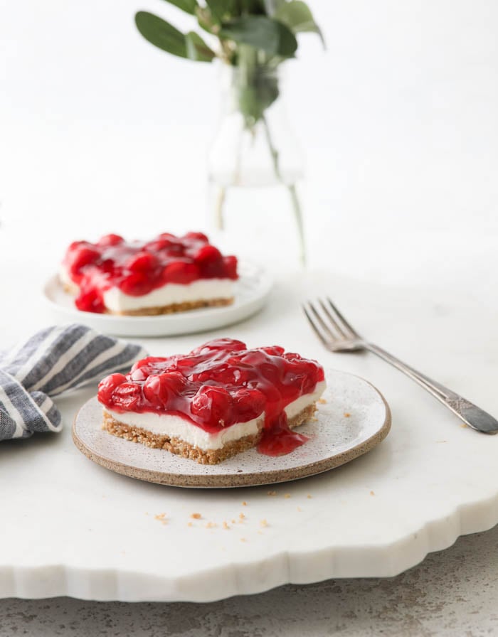 A picture of cherry delight dessert with cherry topping on a plate