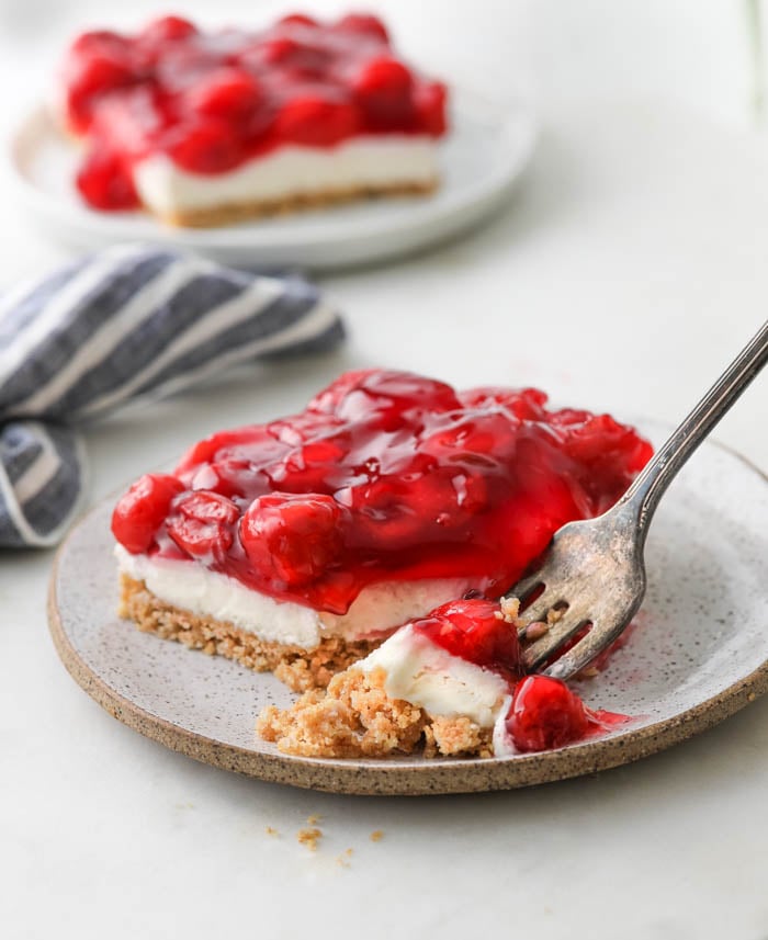 A picture of cherry delight dessert recipe with cherry topping on a plate