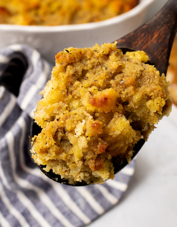 A closeup of a wooden spoonful of cornbread dressing