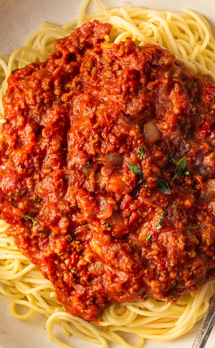A picture of spaghetti sauce with spaghetti on a plate.