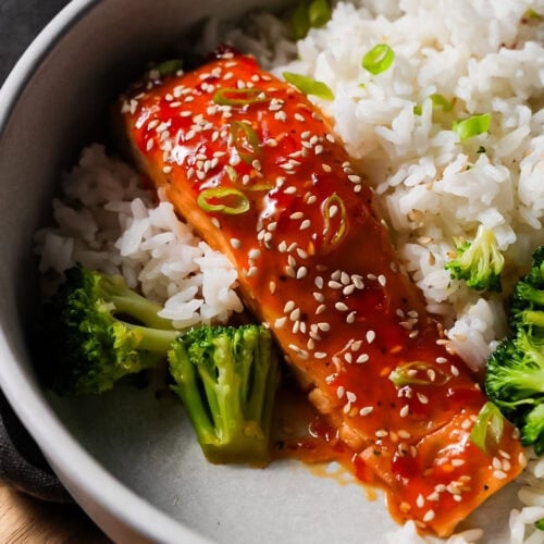 Sweet chili salmon fillet baked until tender, glazed with sticky sweet chili sauce, and garnished with sesame seeds and green onions.