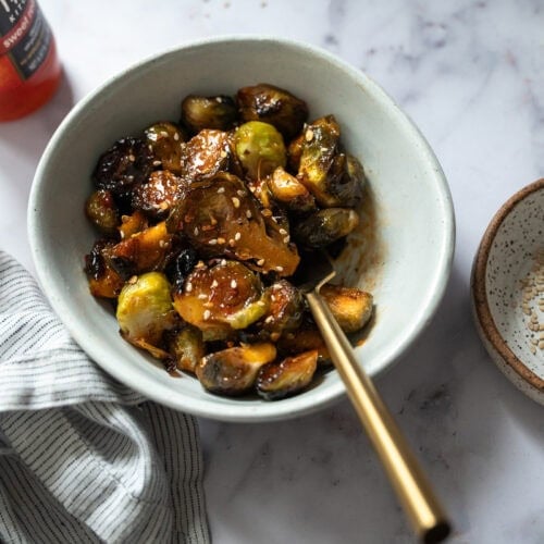 A bowl of roasted brussel sprouts bowl of roasted brussel sprouts and sweet chili glaze A bowl of roasted brussel sprouts and sweet chili glaze