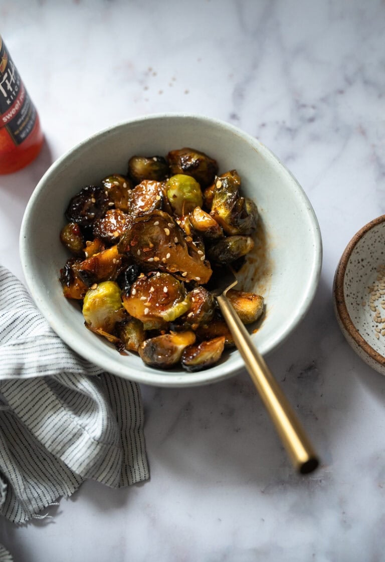 A bowl of roasted brussel sprouts bowl of roasted brussel sprouts and sweet chili glaze A bowl of roasted brussel sprouts and sweet chili glaze