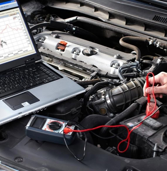 Diagnostic testing of vehicle engine with laptop and multimeter at Winston Wheels & Tires.
