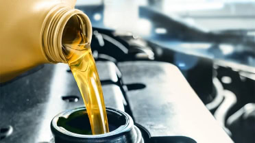 Engine oil being poured into a car engine during maintenance at Winston Wheels & Tires.