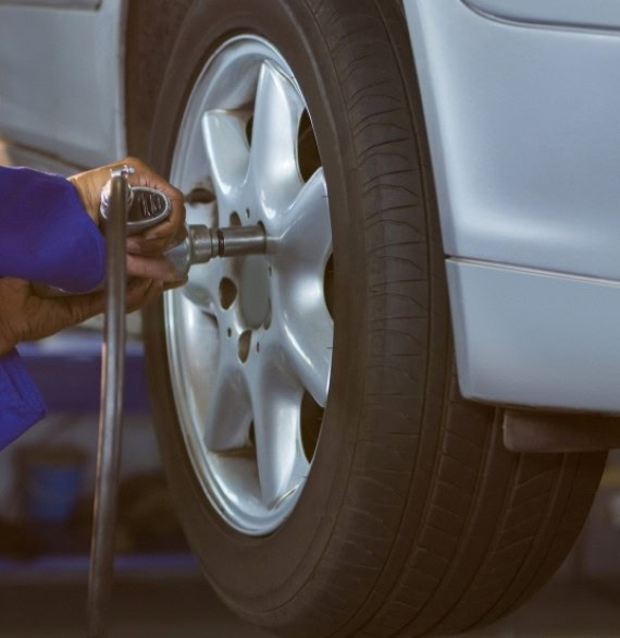 Tire technician installing or repairing a car tire at Winston Wheels & Tires.