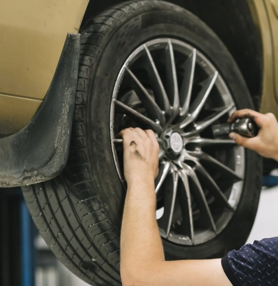 Expert installing high-quality alloy wheel on vehicle with precision and care.