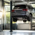 Luxury SUV on hydraulic lift at Winston Wheels & Tires shop.