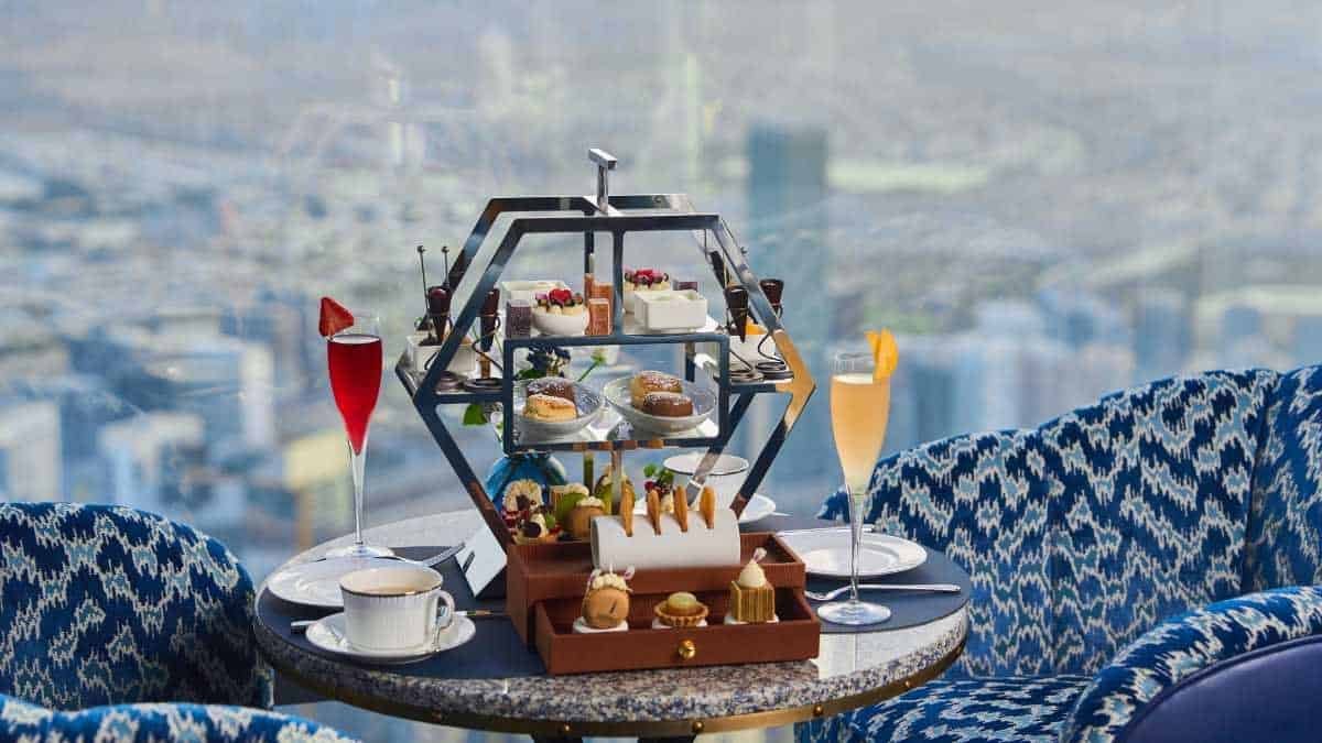 Elegant afternoon tea setup with desserts and drinks at At.mosphere, Burj Khalifa, Dubai.