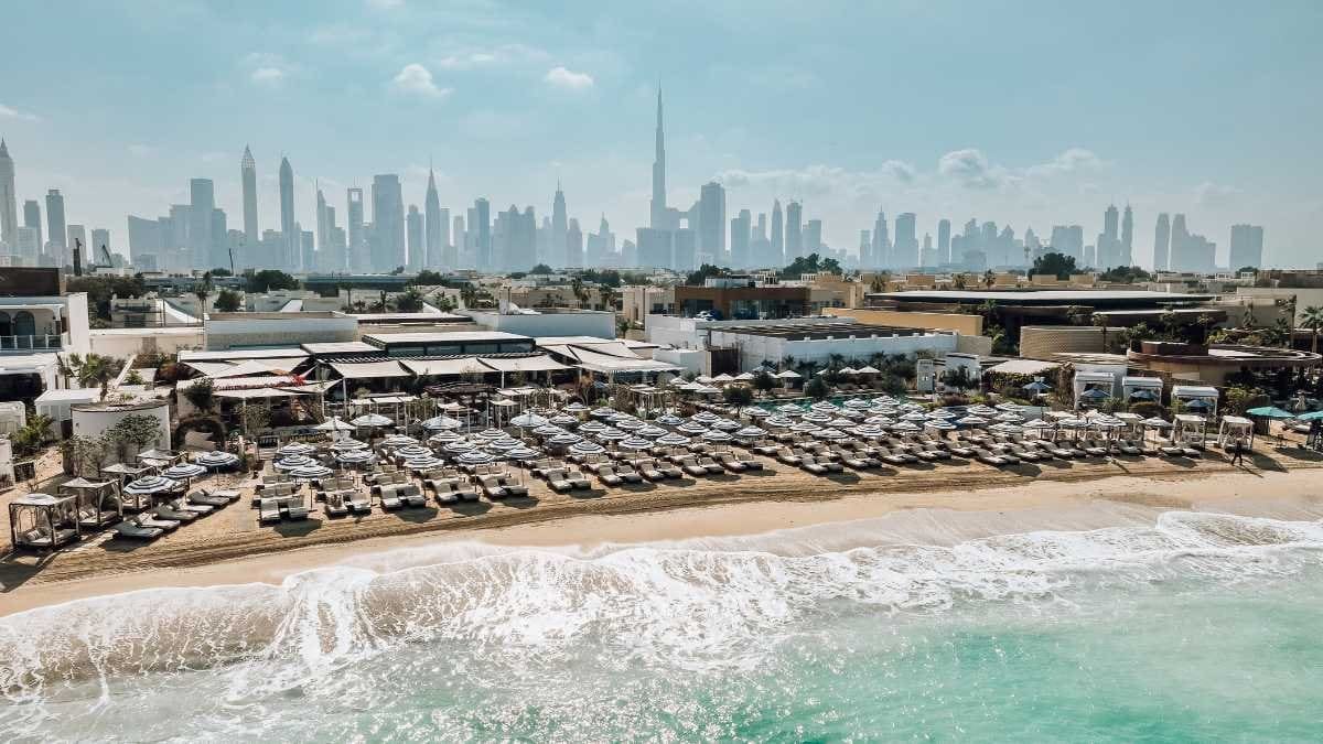 Relaxing yoga session overlooking Dubai skyline and ocean waves at Sirene Beach.