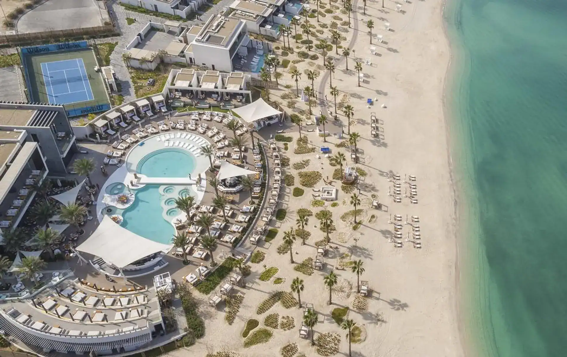 Aerial view of Nikki Beach Resort & Spa Dubai showcasing beachfront, pool, and luxurious amenities.