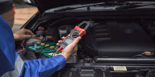 Mechanic inspecting car's electrical system with tools