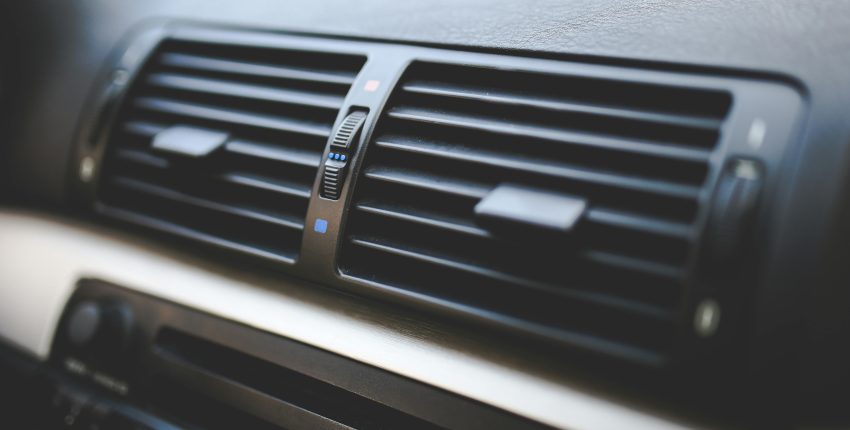 Close-up of car air conditioning vents showing airflow controls.