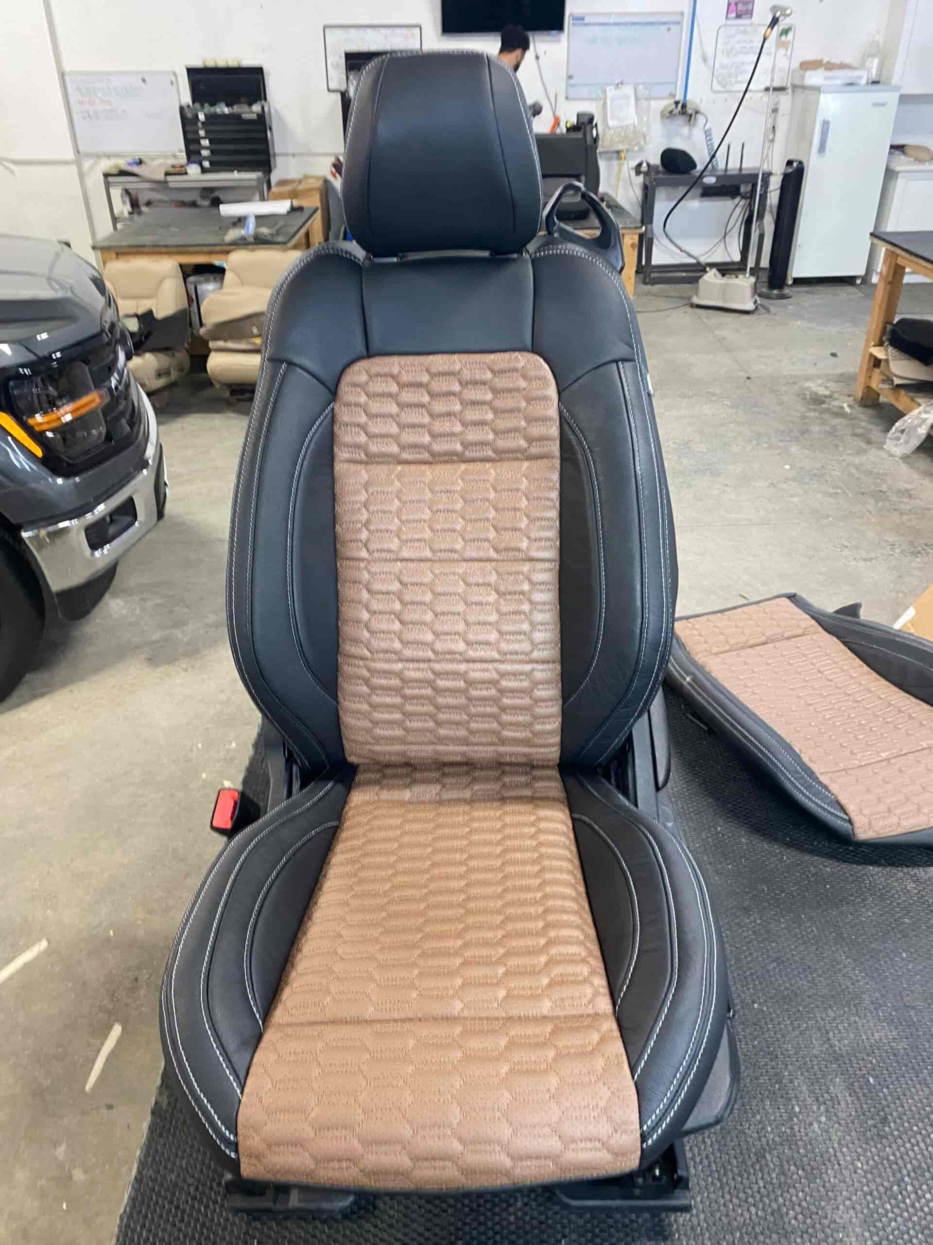 Custom leather car seat with beige quilted insert for comfort and style.