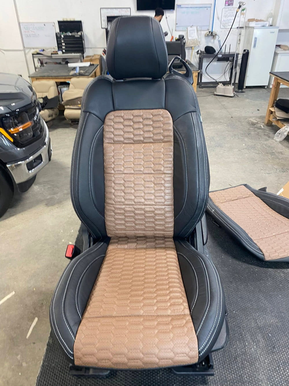 Car seat reupholstery with custom beige and black design.