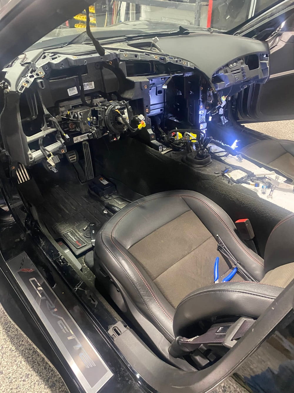Interior dashboard and wiring repair in a vehicle undergoing customization.