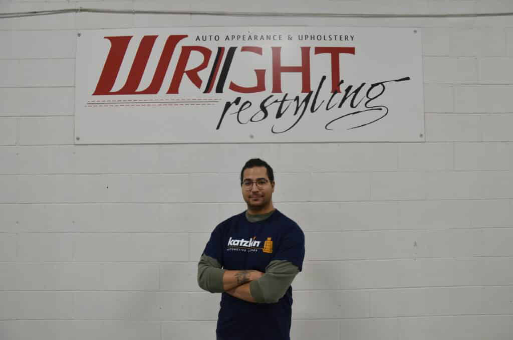 Wright ReStyling auto appearance and upholstery expert with technician in front of logo.