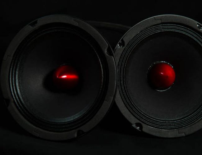 Close-up of black audio speakers with red cones, high-quality sound equipment.