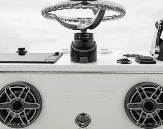 Boat steering console with modern controls and speakers for marine customization.