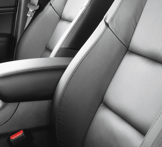 Close-up of sleek, new car seats with premium upholstery and detailed stitching.