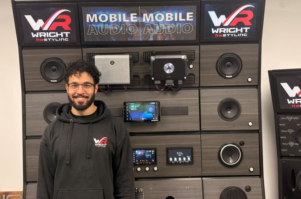 Young man standing in front of mobile audio equipment display at Wright ReStyling.