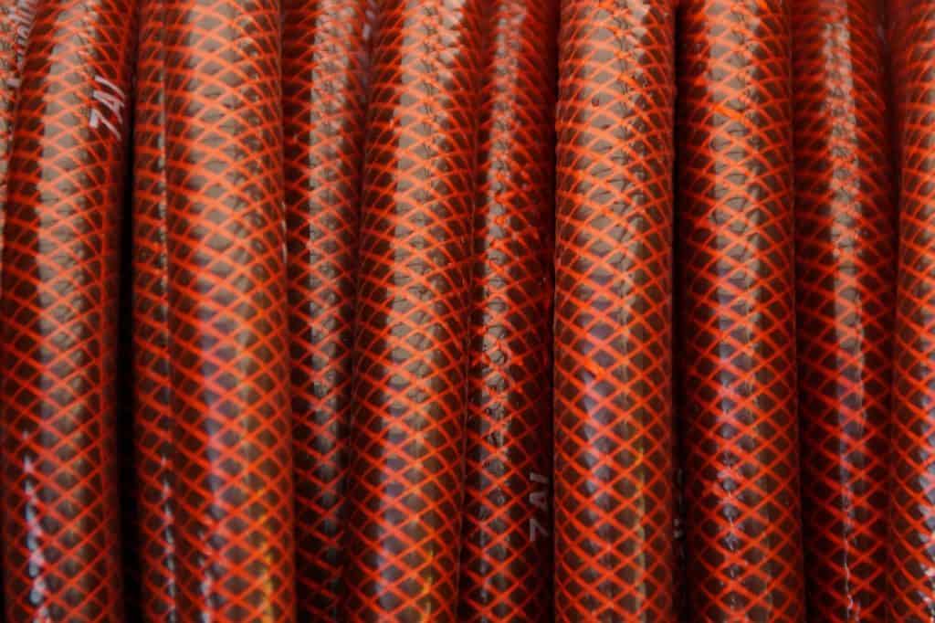 A red garden hose on the article What Is The Longest Garden Hose Available?