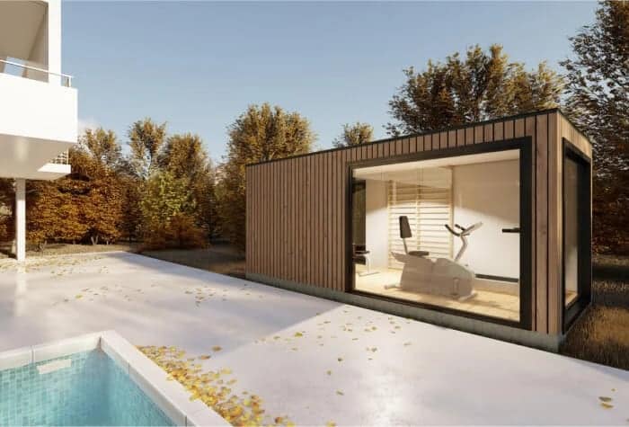 Caseta moderna junto a piscina y árboles otoñales.