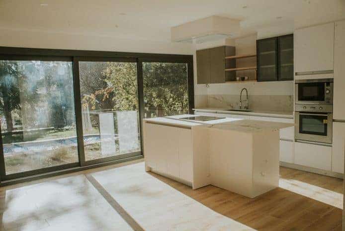 Cocina moderna con isla y ventanal grande.