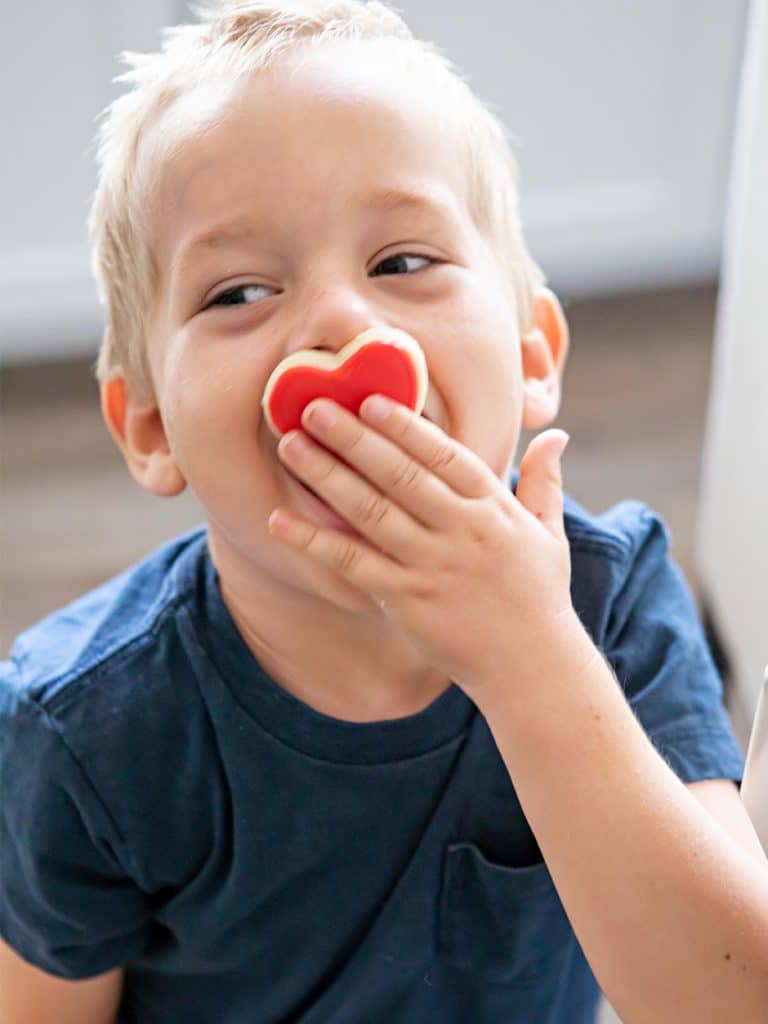boy holding heart cookie over his mouth, family game night ideas