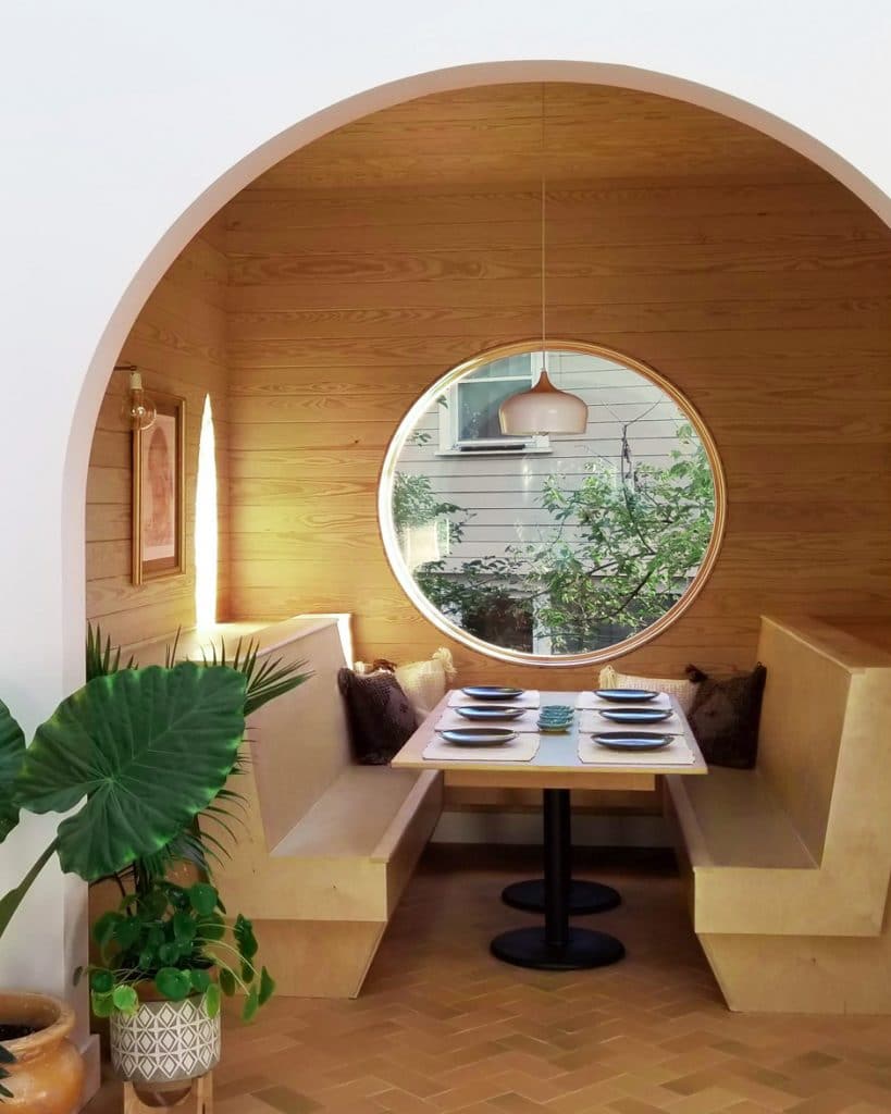 arched entry to breakfast nook with circular window inside eco-friendly house