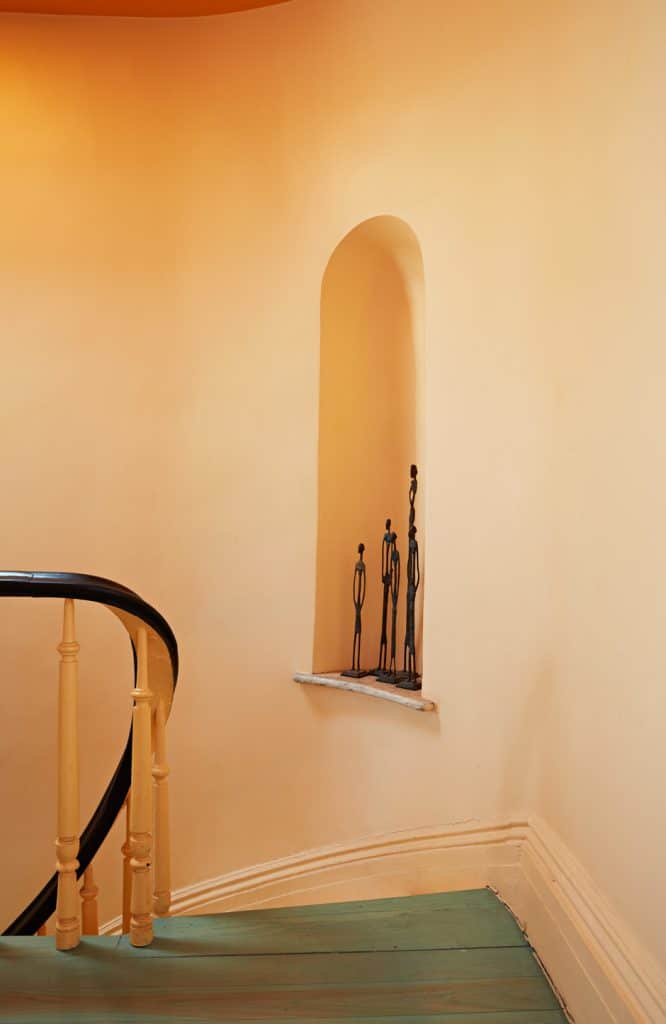 orange walls and turquoise floors at winding staircase