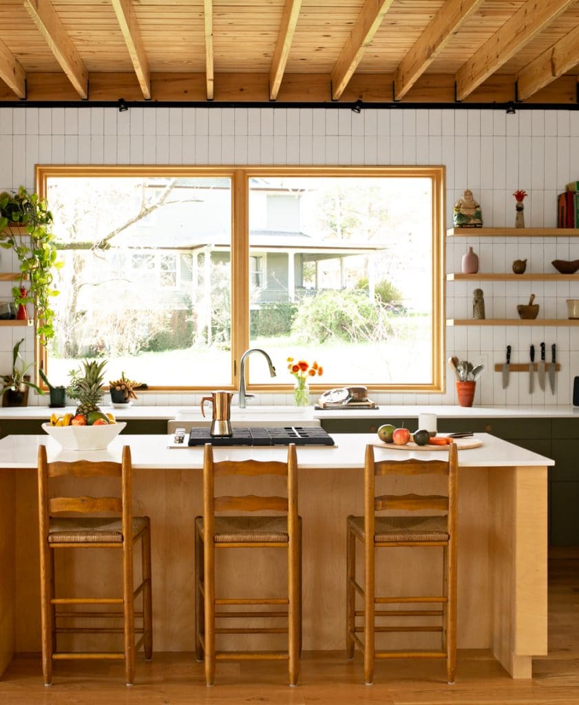 modern white and wooden kitchen with high ceilings and green accents inside eco-friendly house