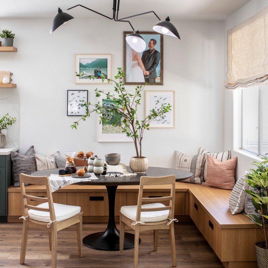 dining nook with L-shaped wooden bench and greenery accents