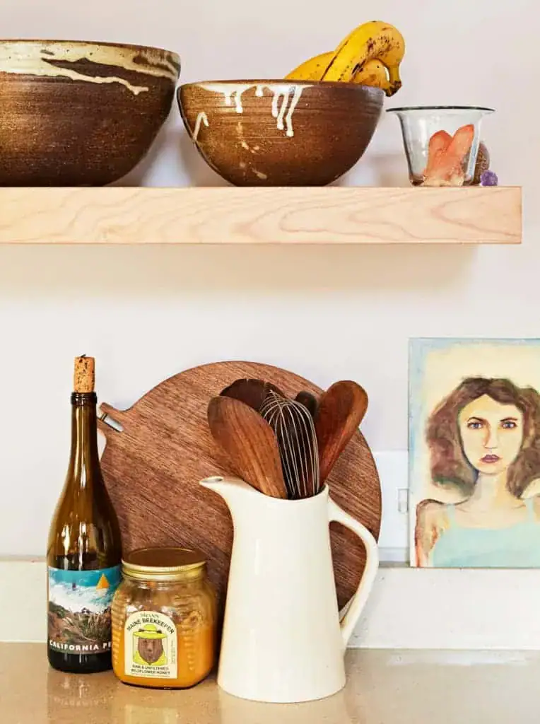 kitchen counter top cutting board, utensils, and bottles