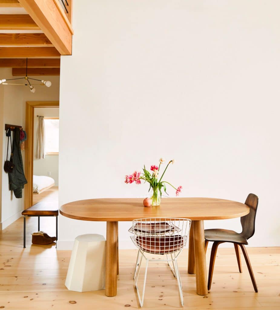 minimalist dining room with smooth wooden table against white wall